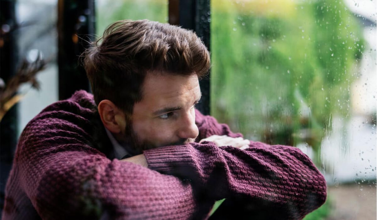 Sad looking man looking out the window
